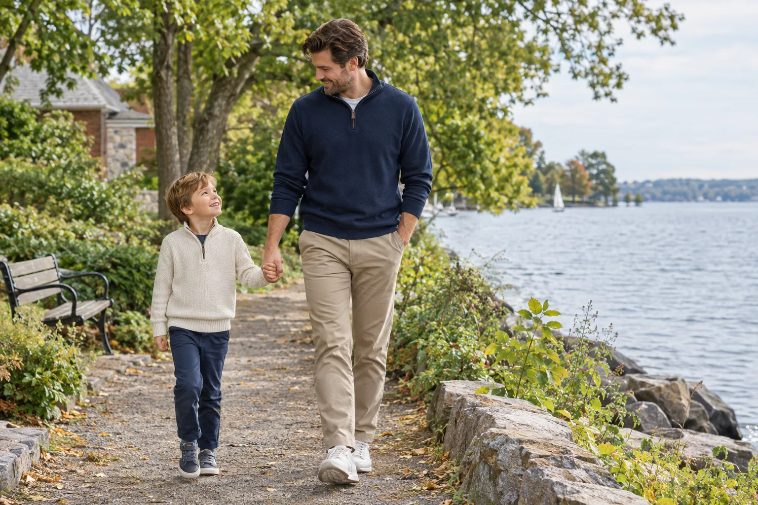 A father and young child walking beside a lake